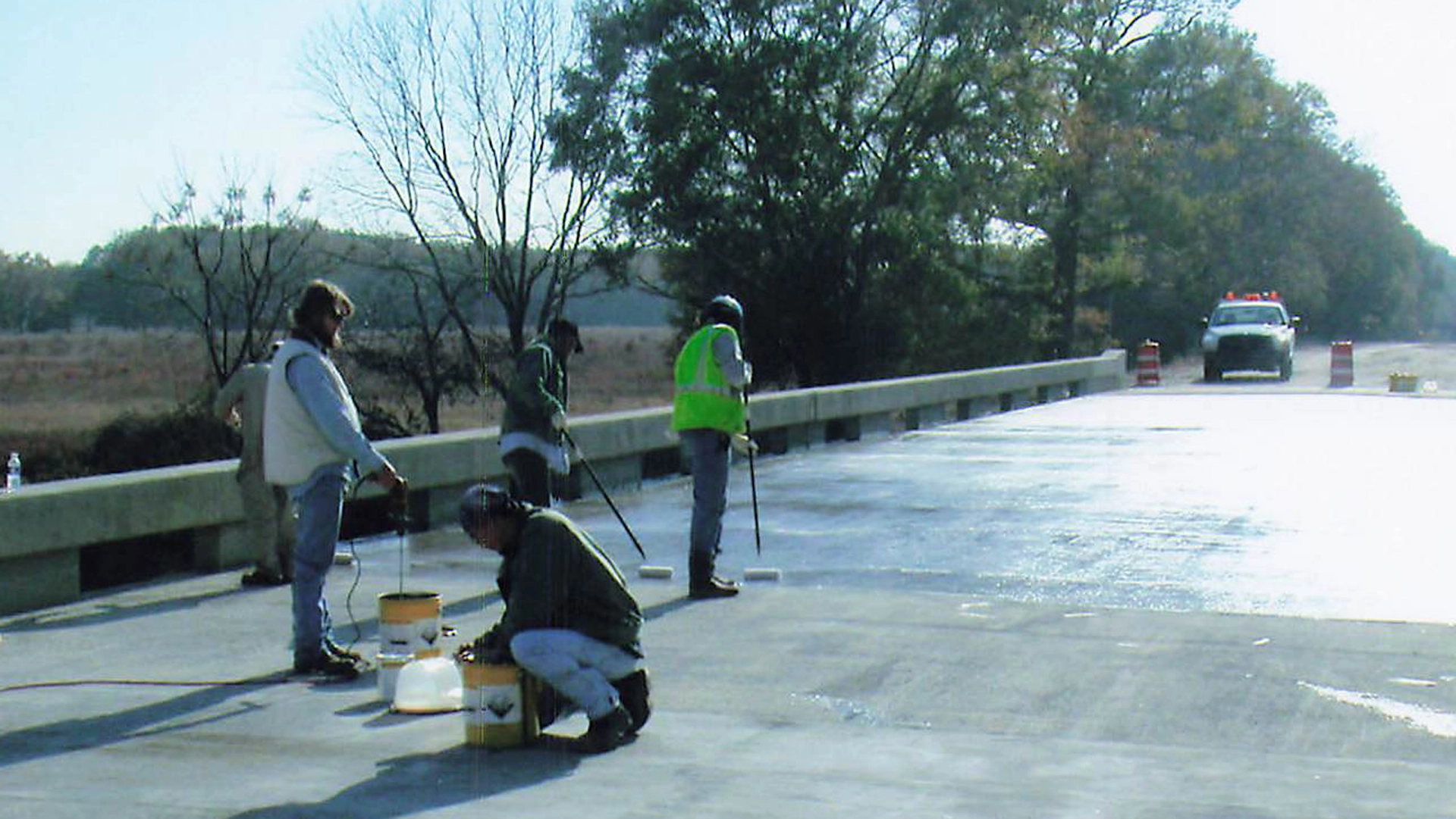 Workers spreading epoxy on bridge surface