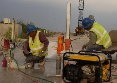 Workers drilling cores in concrete roadway]