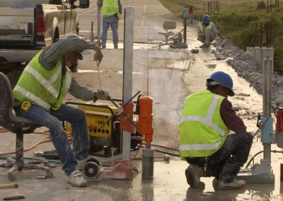 Workers drilling cores in concrete roadway