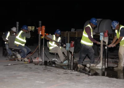 Five workers drilling cores in concrete at night