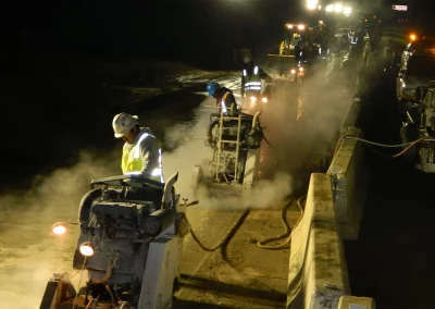 Workers sawing concrete at night