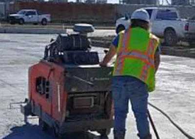 Workman sawing concrete with machine