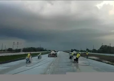 Workers using concrete saws in multiple rows on roadway