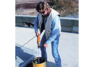 Worker mixing epoxy with drill