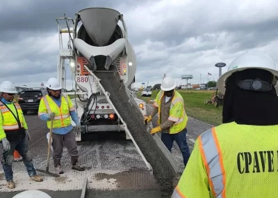 Workman with mixer pouring concrete