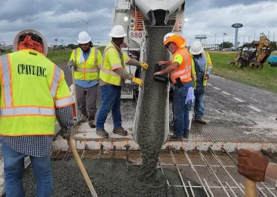 Workers with concrete being poured for roadway repair